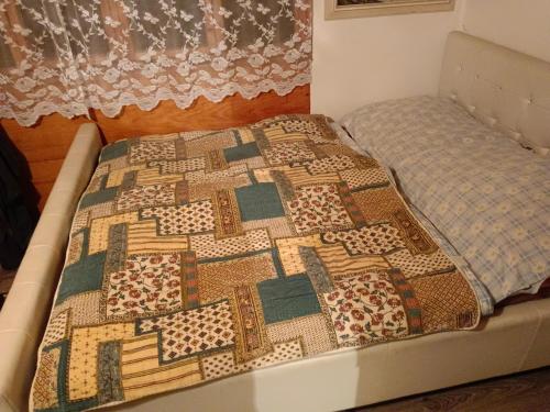 a bed with a quilt on top of it at Chata Evička a Jiříček in Raškovice