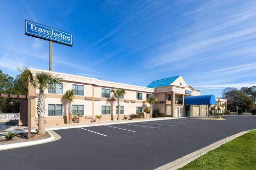 a hotel with a street sign in a parking lot at Travelodge by Wyndham Perry National Fairgrounds Area I-75 in Perry
