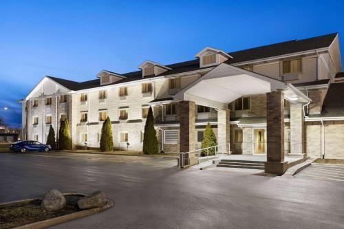 a large building with a parking lot in front of it at Super 8 by Wyndham Joliet I-55 N/Chicago in Joliet