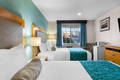a hotel room with two beds and a window at Howard Johnson by Wyndham Santa Cruz in Santa Cruz