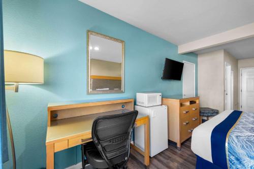 a hotel room with a desk and a bed and a bedroom at Howard Johnson by Wyndham Santa Cruz in Santa Cruz