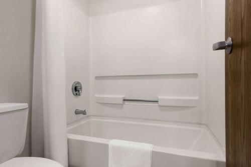a bathroom with a white tub and a toilet at Super 8 by Wyndham Joliet I-55 N/Chicago in Joliet