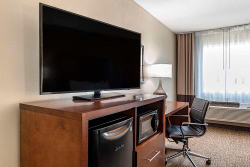 a hotel room with a large flat screen television on a desk at Comfort Inn in Crawfordsville