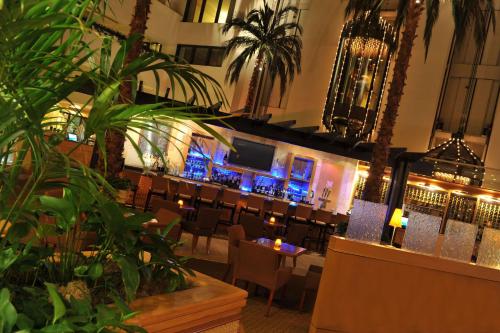 a restaurant with chairs and a bar with blue lights at Hilton Orange County/Costa Mesa in Costa Mesa
