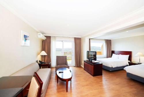 a hotel room with a bed and a couch at La Vie Dor Hotel and Resort, Trademark Collection by Wyndham in Hwaseong