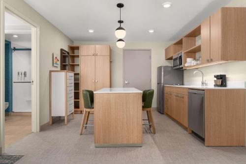 a kitchen with wooden cabinets and a kitchen island at Homewood Suites By Hilton North Las Vegas Speedway in Las Vegas