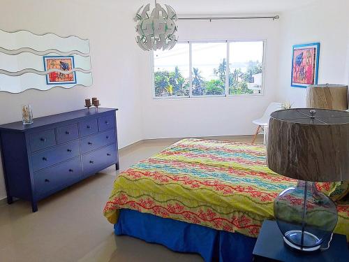 a bedroom with a bed and a dresser and a window at Vista Marina Residence in Boca Chica