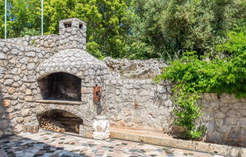 a stone fireplace with a statue in front of it at Denjak Apartments in Kornić