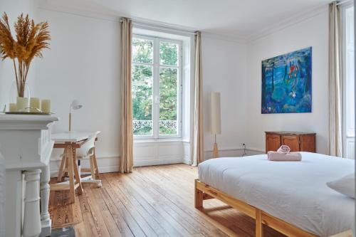 une chambre blanche avec un lit et un bureau dans l'établissement Manoir de la Plume, à Saint-Sébastien-sur-Loire