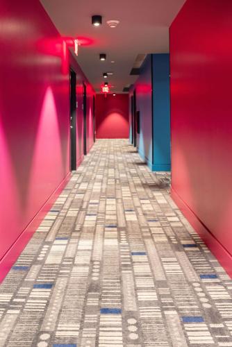a corridor with pink walls and a long hallway at Lorenzo Hotel Dallas, Tapestry Collection by Hilton in Dallas