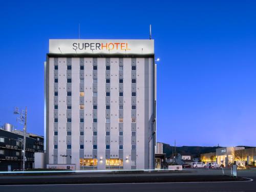 a hotel building with a sign on top of it at Super Hotel Gotemba Nigo-Kan in Gotemba
