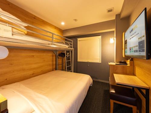 a hotel room with a bed and a flat screen tv at Super Hotel Gotemba Nigo-Kan in Gotemba