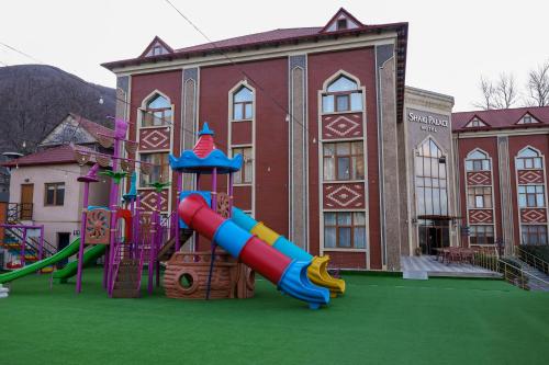 a playground with a slide in front of a building at Sheki Palace Hotel in Sheki