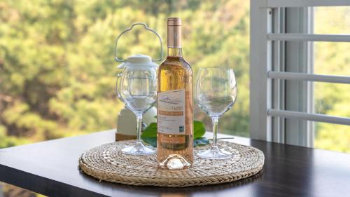 a bottle of wine and two wine glasses on a table at seonjaedo secret spa pension in Incheon