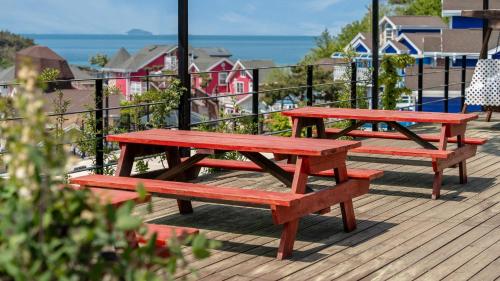 three picnic tables on a deck with the ocean in the background at seonjaedo secret spa pension in Incheon