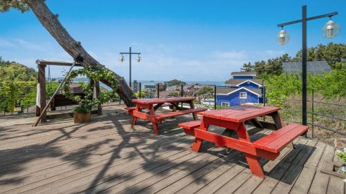 two red benches sitting on a wooden deck at seonjaedo secret spa pension in Incheon