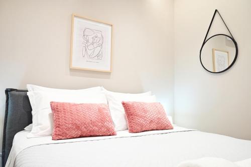 a bedroom with a bed with two pink pillows at Dido's house in Volos