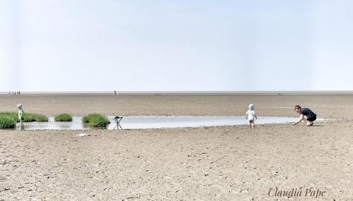 a man and a child playing on the beach at Ferienhaus Nordkönig mit Sauna und Whirlpool in Langen