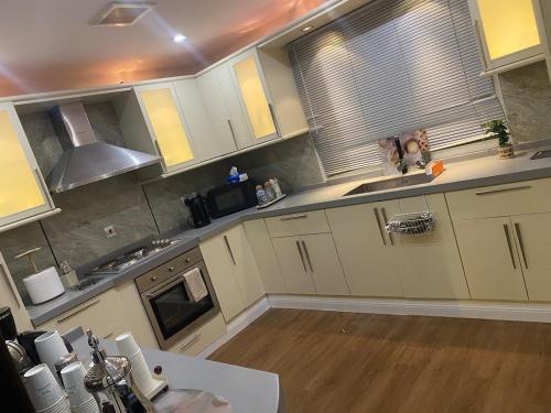 a kitchen with white cabinets and a wooden floor at ڤيلا المرجان للعائلة Murjan Family Villa in Yanbu