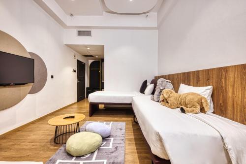 a teddy bear sitting on a bed in a room at Owen House by Habyt in Singapore