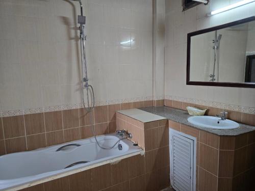 a bathroom with a bath tub and a sink at Thavisouk Hotel, Vang Vieng in Vang Vieng
