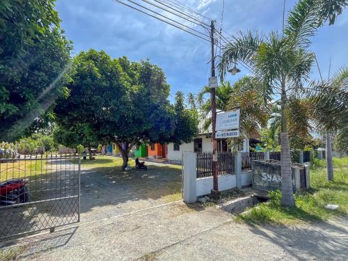 a fence in front of a park with trees at RedDoorz Syariah at Home Ampana Guest House Ampana Kota in Dondo