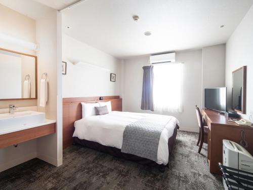 a hotel room with a bed and a sink at Vessel Hotel Fukuoka Kaizuka in Fukuoka