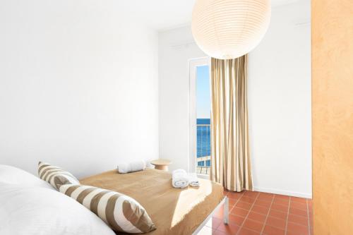 a bedroom with a bed and a large window at Milnamour, Whole House by the Sea with Parking in Hvar