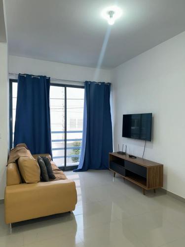 a living room with a couch and a television at Apartamento Novo, Brand New Apartament T1, Cidadela, Praia, Cabo Verde in Praia