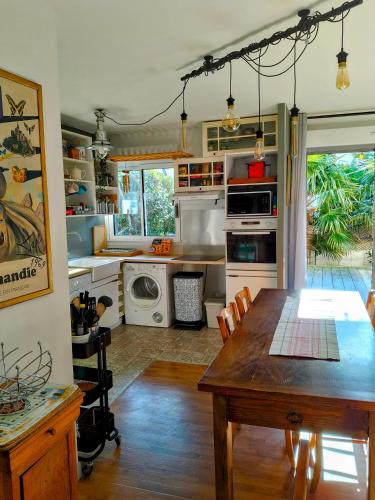 une cuisine avec une table en bois et une salle à manger dans l'établissement Grand appartement 3 pièces, terrasse au sud et mer à 80m, à Cabourg