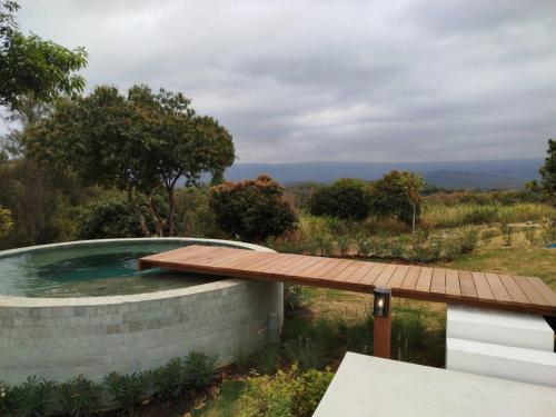 a plunge pool with a wooden deck and a wooden table at Roukh Kiri Khaoyai, The Centara Collection in Pak Chong