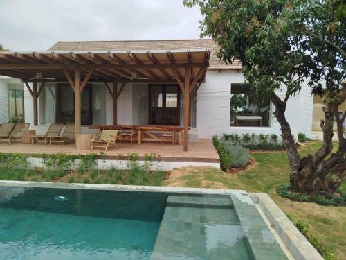 a house with a swimming pool in front of a house at Roukh Kiri Khaoyai, The Centara Collection in Pak Chong