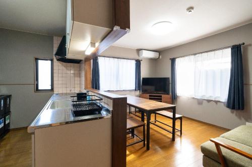 a kitchen with a counter and a table in a room at The Nekozane HAUS in Urayasu