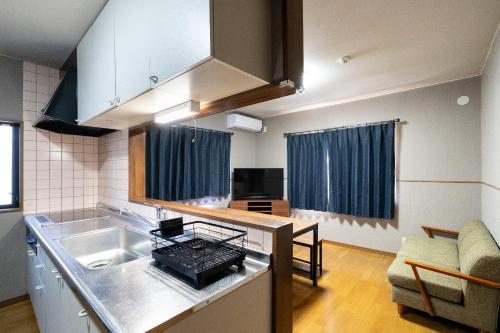 a kitchen with a sink and a stove top oven at The Nekozane HAUS in Urayasu