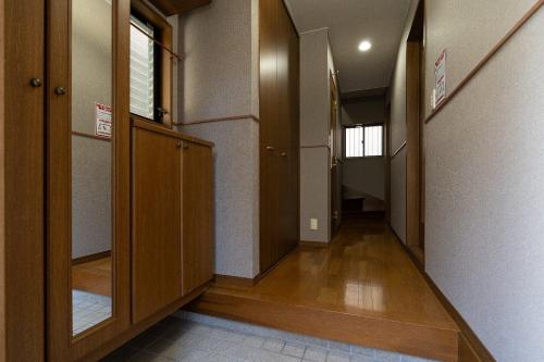 an empty hallway with wooden doors and a hallway at The Nekozane HAUS in Urayasu