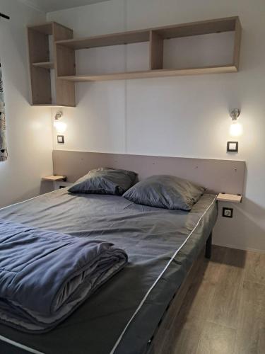 - un grand lit dans une chambre avec 2 oreillers dans l'établissement camping les oyats, à Seignosse