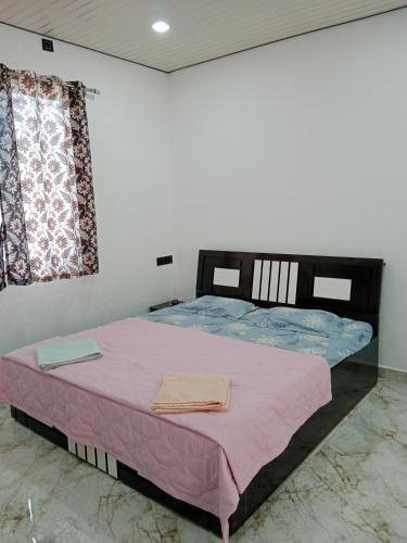 a bedroom with a large bed with pink sheets at sukhwan BY WILD FLOWER in Mulshi