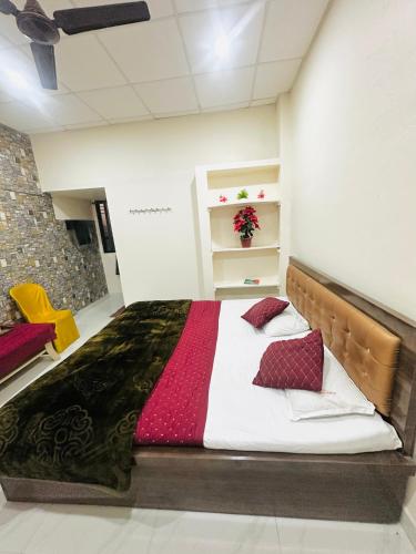 a bedroom with a large bed with red pillows at Hotel Tathastu in Rāmtek