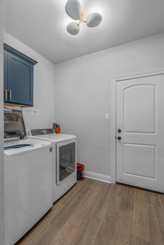 a kitchen with white appliances and a white door at Groovy, New & Modern! Tv in each room in Shreveport