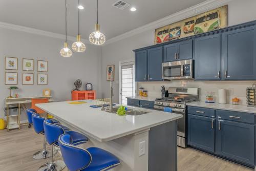 a kitchen with blue cabinets and a white counter top at Groovy, New & Modern! Tv in each room in Shreveport