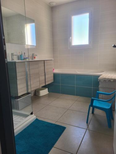 La salle de bains est pourvue d'une chaise bleue et d'un lavabo. dans l'établissement Villa au coeur du village de Castanet, à Castanet