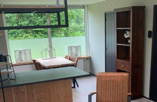 a room with a table and chairs and a window at Bungalow Zandzegge | 4 personen - Vakantiepark De Kremmer in Gasselte