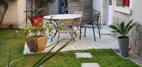 un patio avec une table, des chaises et des plantes dans l'établissement Chambre aux portes de Chambord, à Huisseau-sur-Cosson