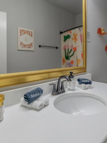 a white bathroom sink with a mirror and a sink at Groovy, New & Modern! Tv in each room in Shreveport
