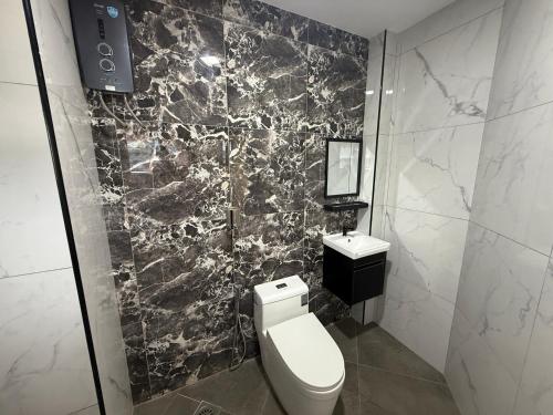 a black and white bathroom with a toilet and a sink at Radiant Heights Hotel by KK Inn in Ampang