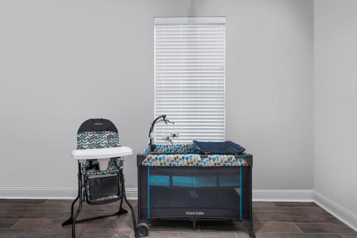 a room with a chair and a table and a television at Groovy, New & Modern! Tv in each room in Shreveport