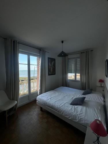 a bedroom with a bed and a large window at Les Villas de Puys - Dieppe in Dieppe
