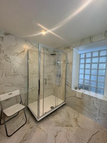 a bathroom with a shower with a chair in it at Les Villas de Puys - Dieppe in Dieppe