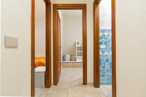 een gang met een deur die naar een slaapkamer leidt bij Villetta Lu Lioni in San Teodoro