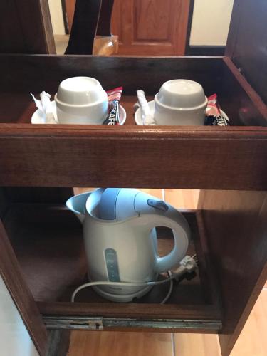a wooden cabinet with three dishes and a tea pot at บ้านต้นรักษ์ BanTonRuk Takuapa in Takua Pa